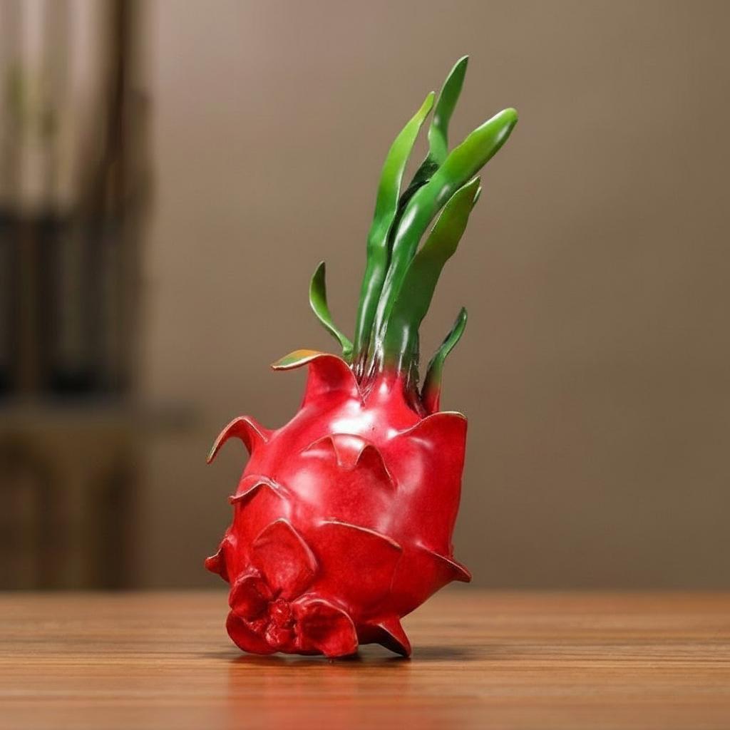 Angled view showing the red skin and green leaves of the brass sculpture