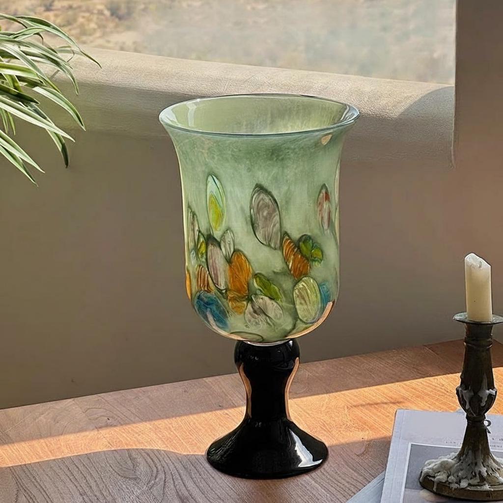 Green art glass vase with yellow floral arrangement