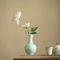 Patterned ceramic bud vase with white flowers