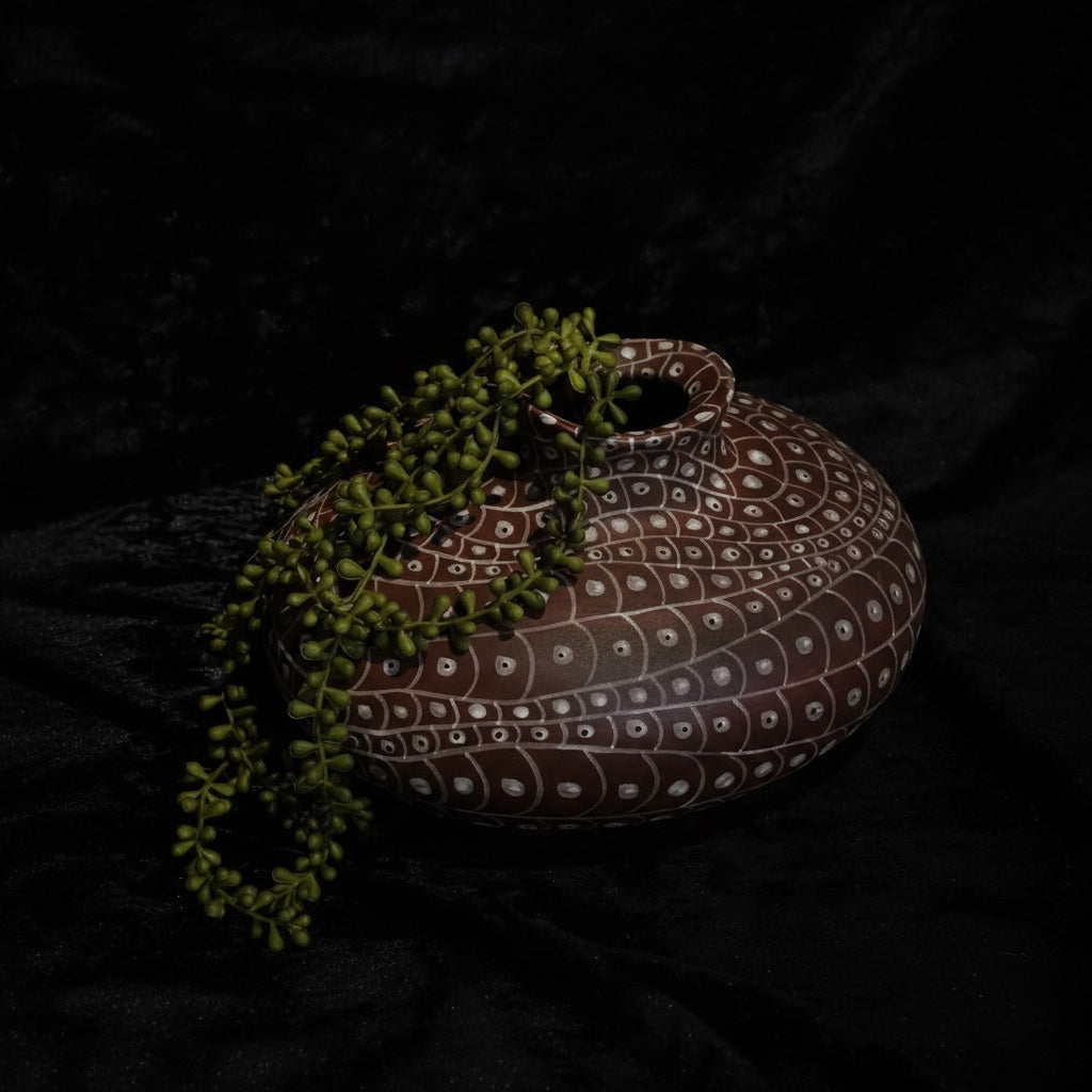 Patterned terracotta orb vase styled with greenery