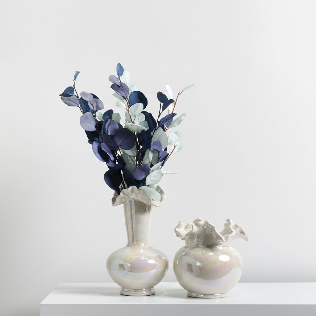 Pearlescent ceramic ruffled rim vases styled with blue foliage
