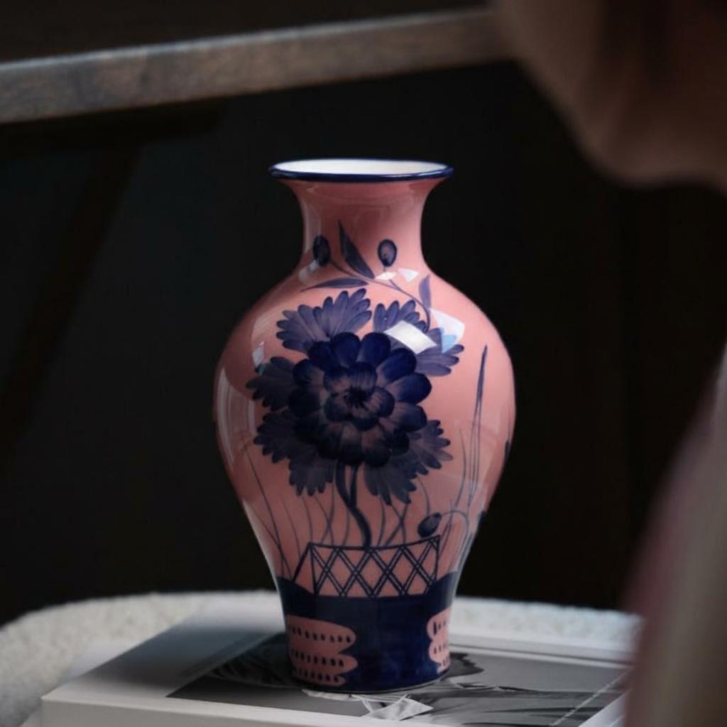 Front view of pink and blue ceramic floral vase on table