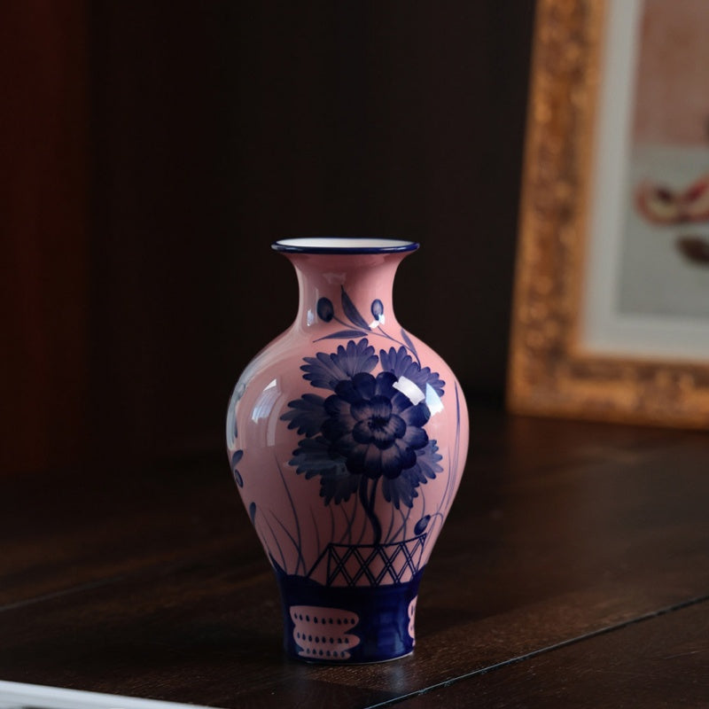 Angled view of pink ceramic vase with blue flower pattern