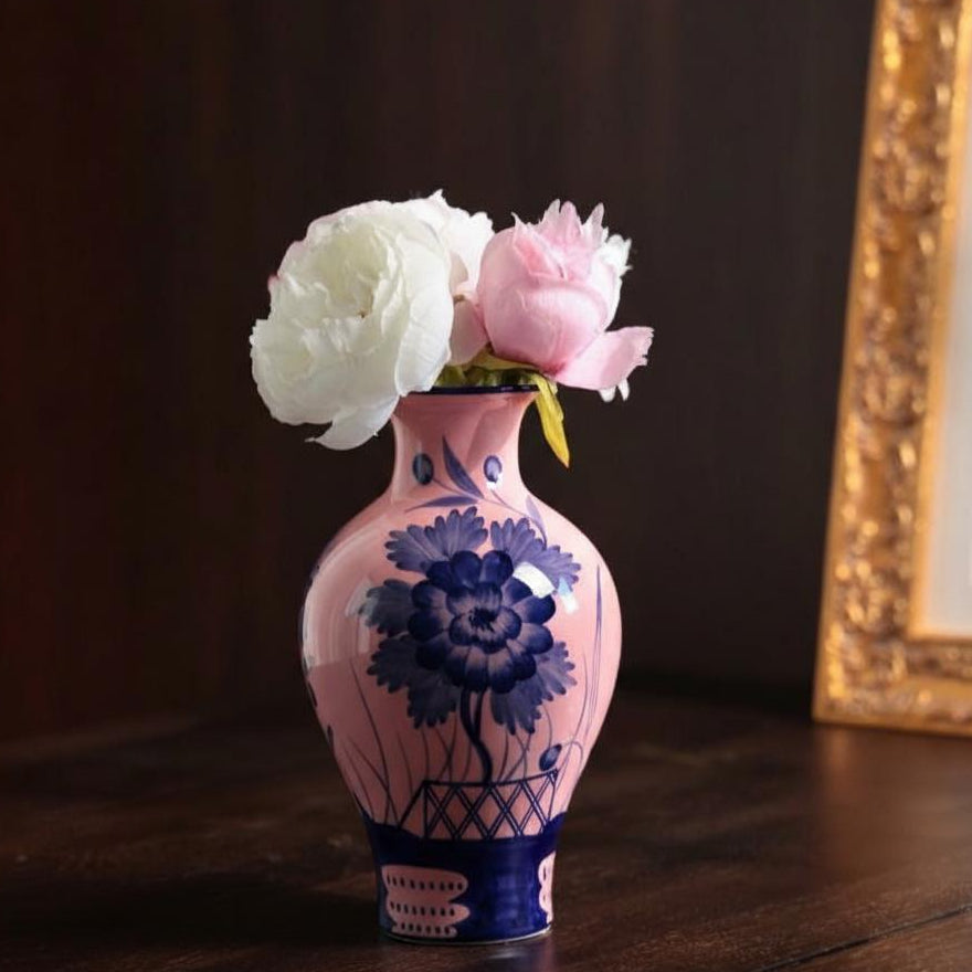 Pink and blue ceramic vase holding flowers
