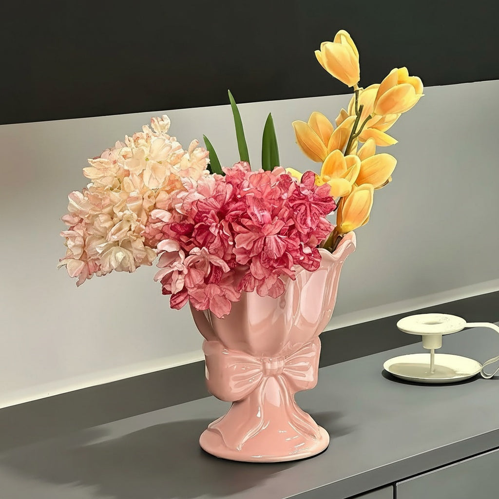 Close up of pink ceramic bow pedestal vase with blooms