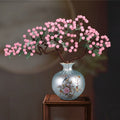 Front view of pink crystal bonsai in blue porcelain vase