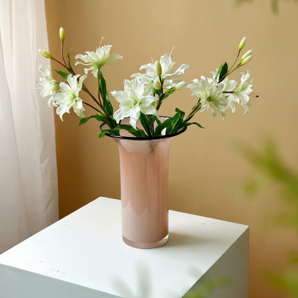 Pink glass flared vase with white lilies on pedestal