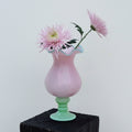 Front view of pink and green glass vase with flowers