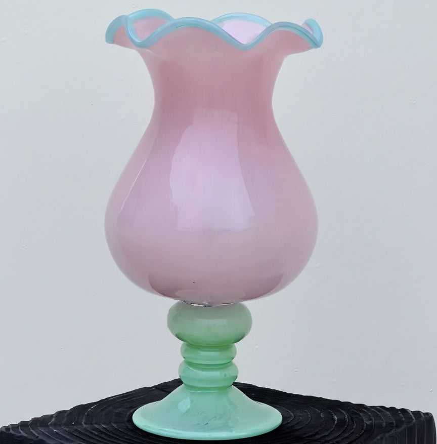 Front view of pink and green glass pedestal vase without flowers