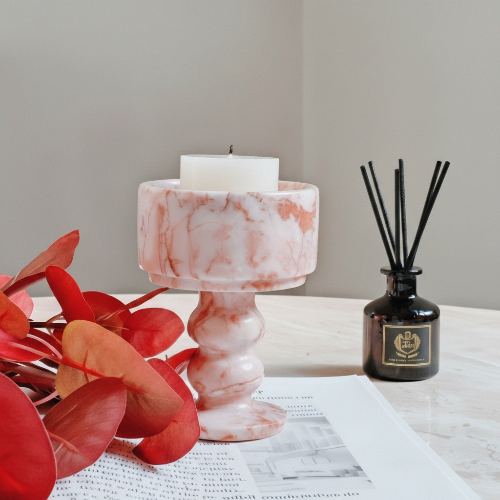 Pink marble chalice candle holder holding white pillar candle