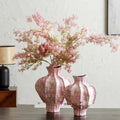 Group shot of medium and large pink ceramic vases with floral arrangements