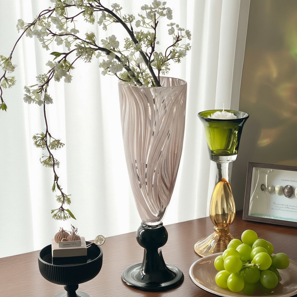 Pink glass pedestal vase styled with greenery and candle