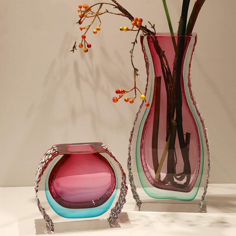 Two pink and teal crystal vases with textured edges on display