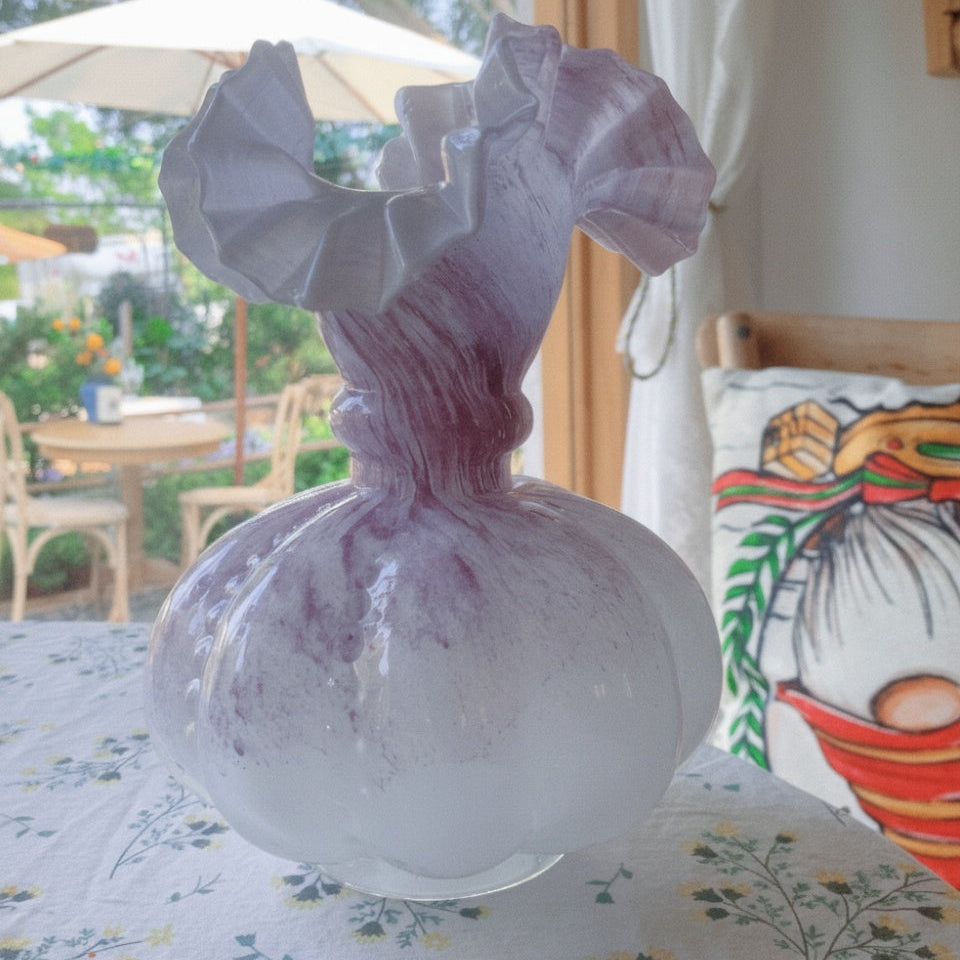 Side view of pink art glass vase on table