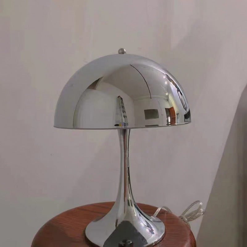 Polished chrome dome table lamp on wooden table