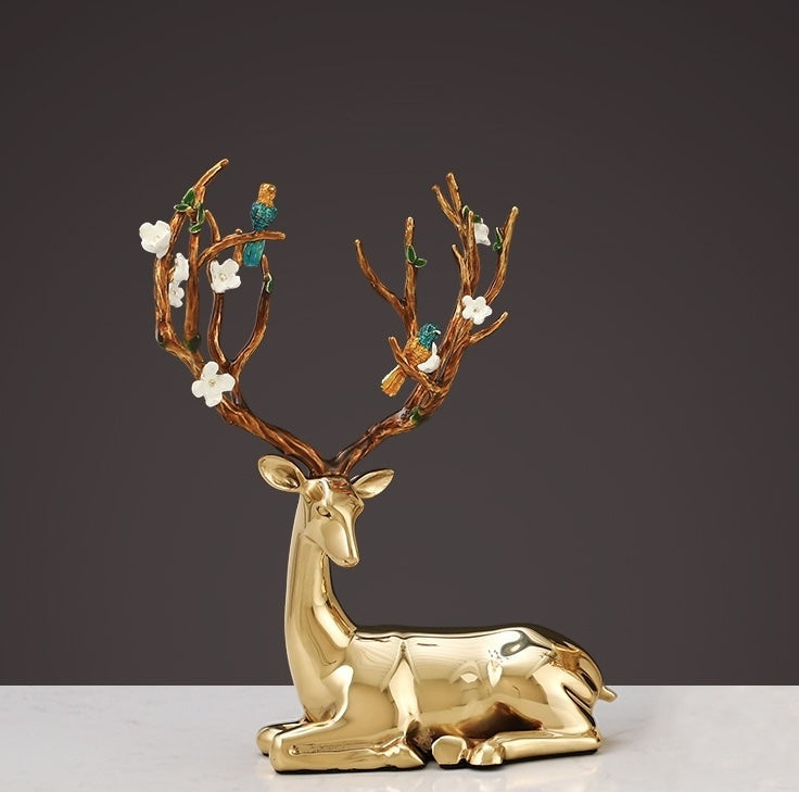 Side view of sitting gold finish deer statue