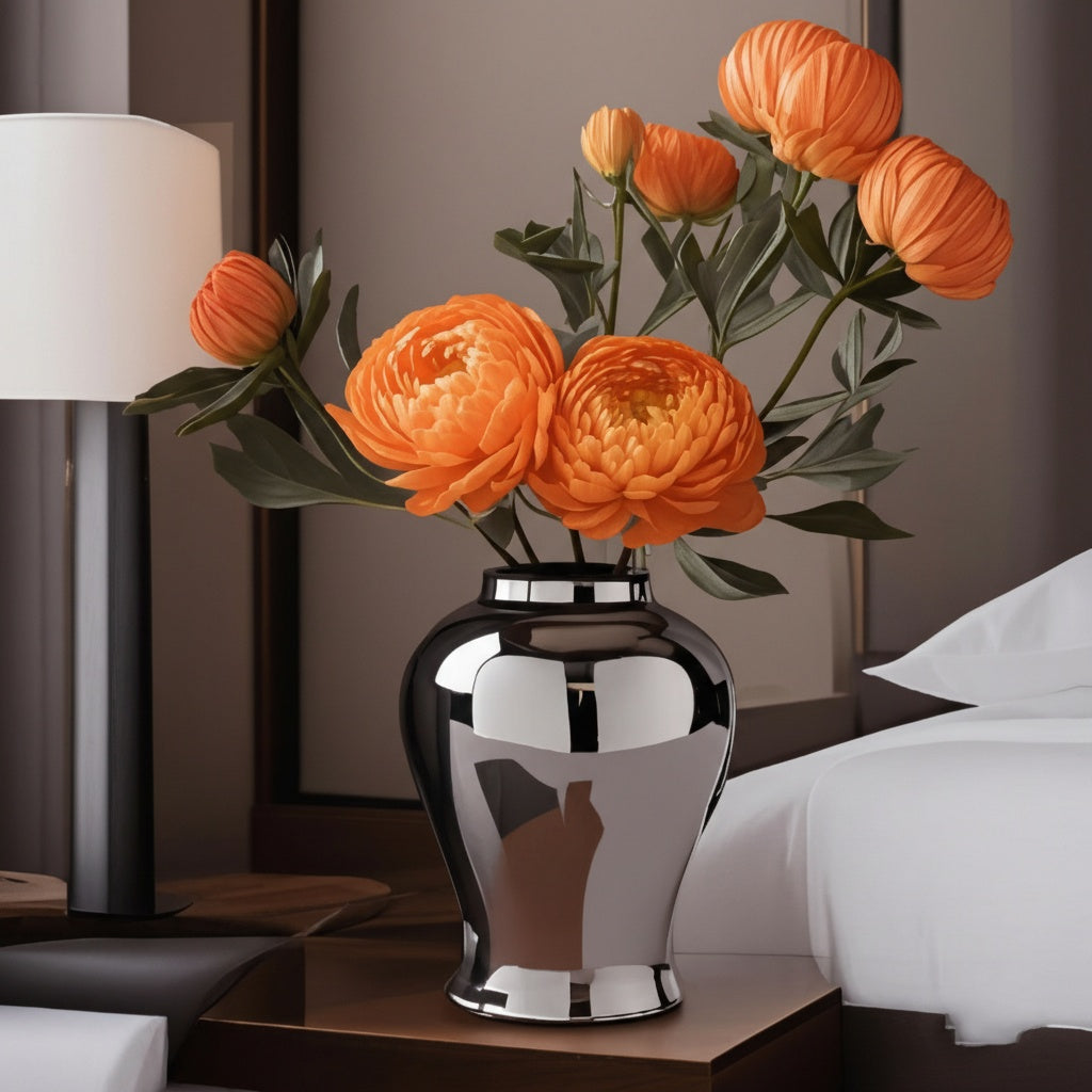 Reflective silver table vase on bedside table with lamp