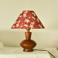 Front view of polished wood gourd table lamp with red floral shade