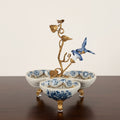 Front view of crackle porcelain trefoil centerpiece with brass bird sculpture