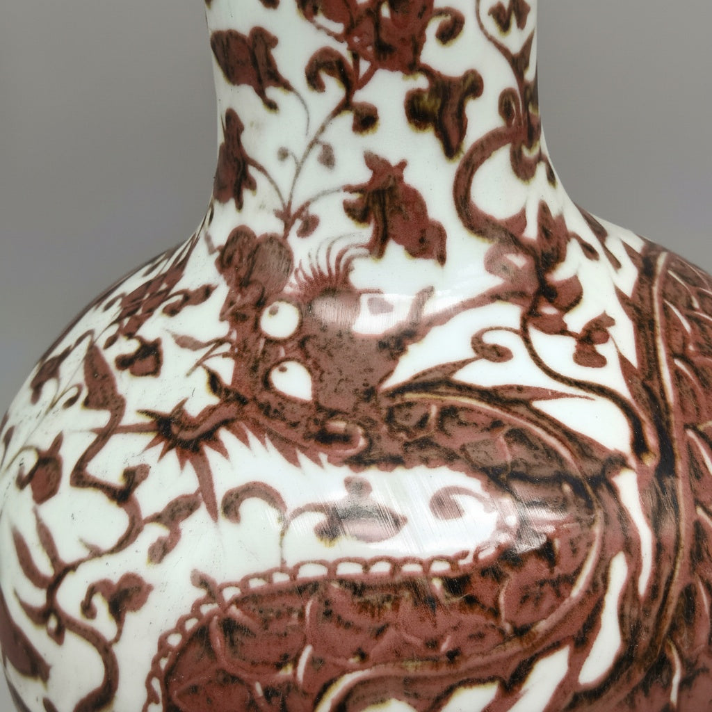 Close-up of the painted crimson dragon details on the vase neck