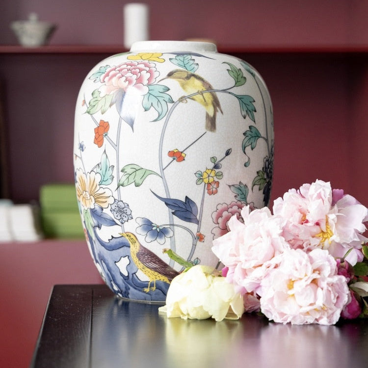 Lifestyle shot of porcelain jar on table with flowers