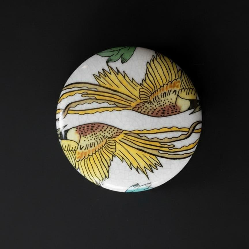 Detail view of jar lid featuring yellow bird design