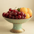 Close up of porcelain pedestal fruit bowl holding fresh cherries