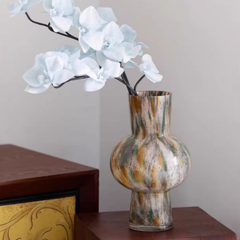 Art glass vase with white orchids on side table