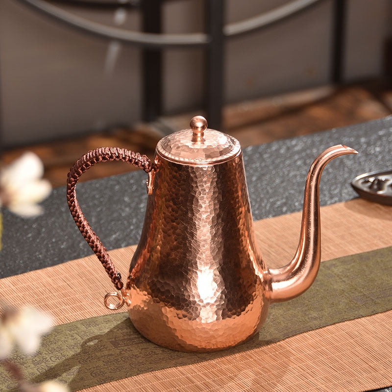 Handcrafted hammered copper kettle on tea table