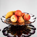 Crystal fruit bowl filled with mangoes and apples