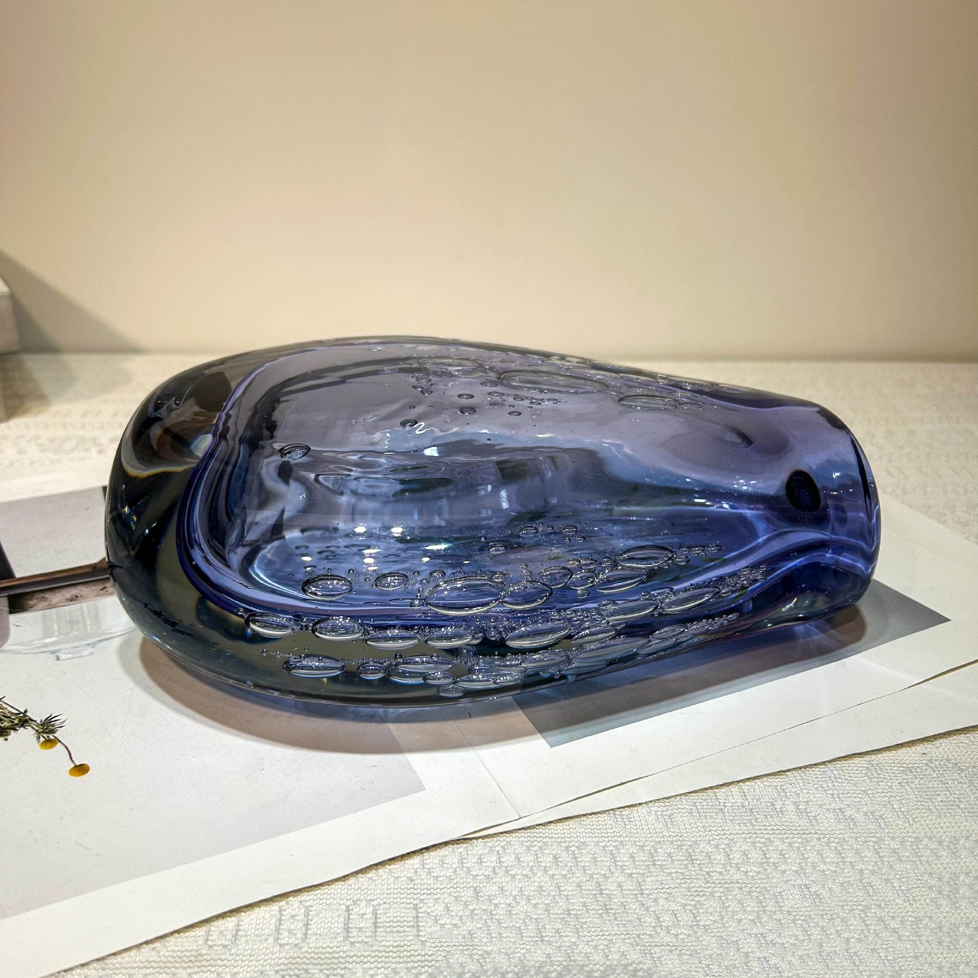 Side view of thick purple glass vase lying flat