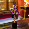 Purple glass and gold botanical sculpture on a display table