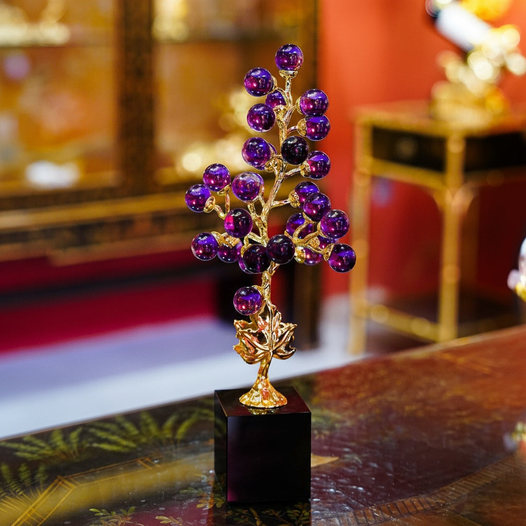 Purple glass and gold botanical sculpture on a display table
