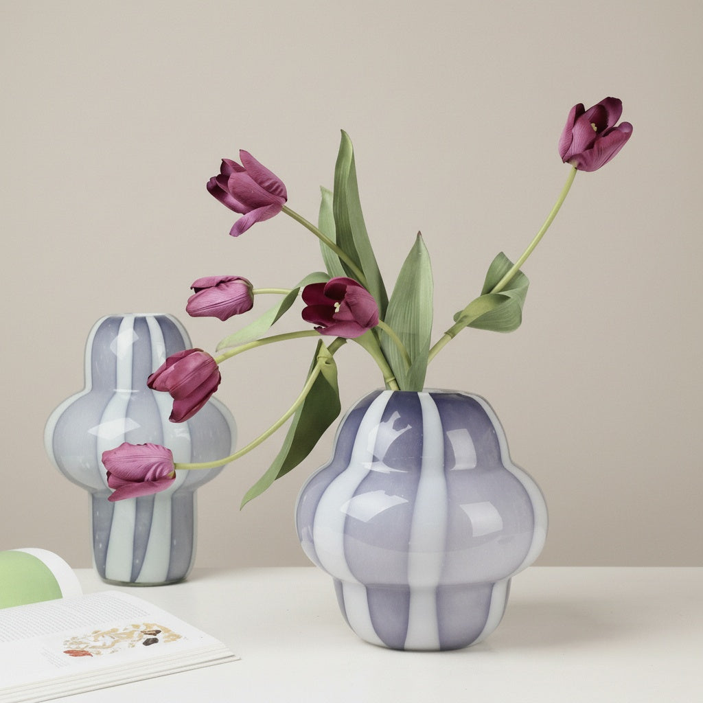 Two purple and white striped glass sculptural vases with tulips