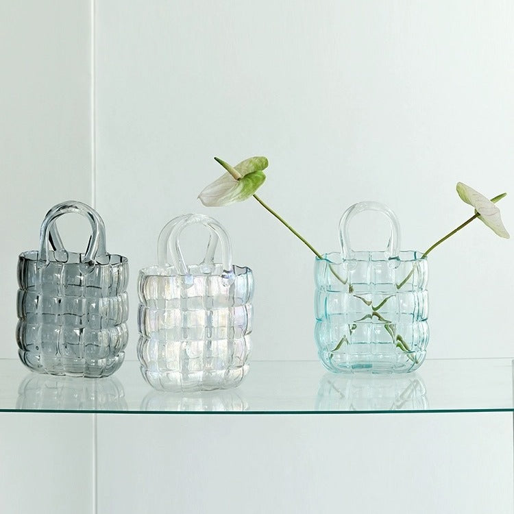 Trio of glass handbag vases on shelf