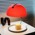 Red acrylic dome table lamp with chrome base on white table