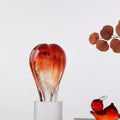 Red and amber art glass sculpture on clear base