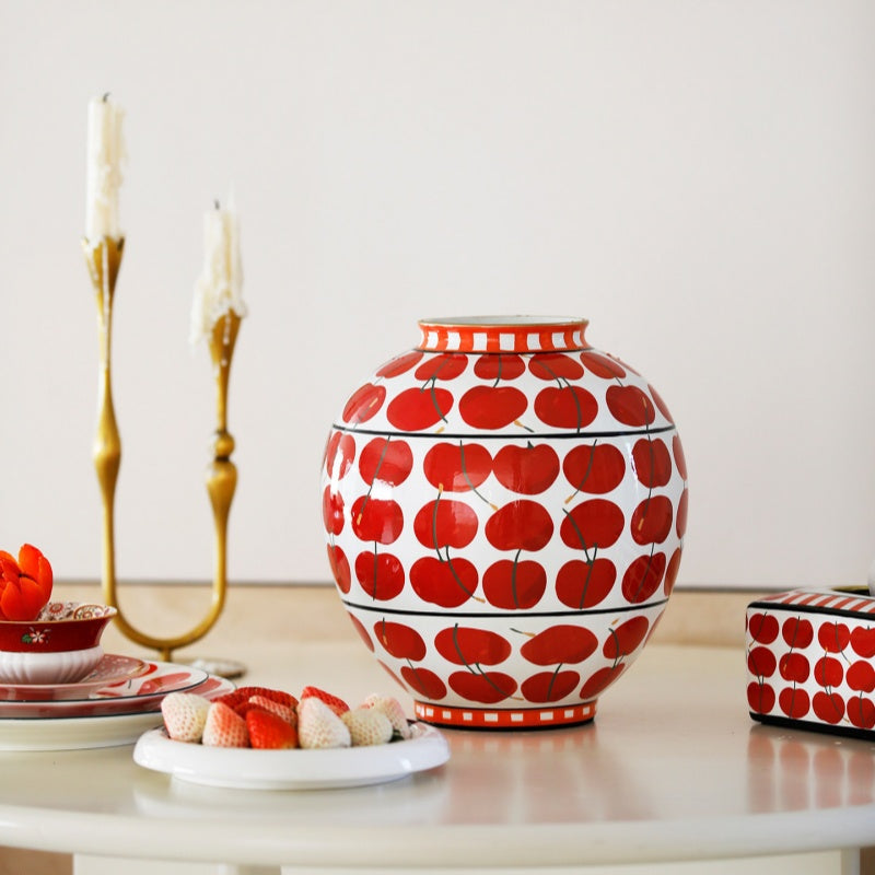 Front view of white porcelain vase with red apple motif and checkered rim