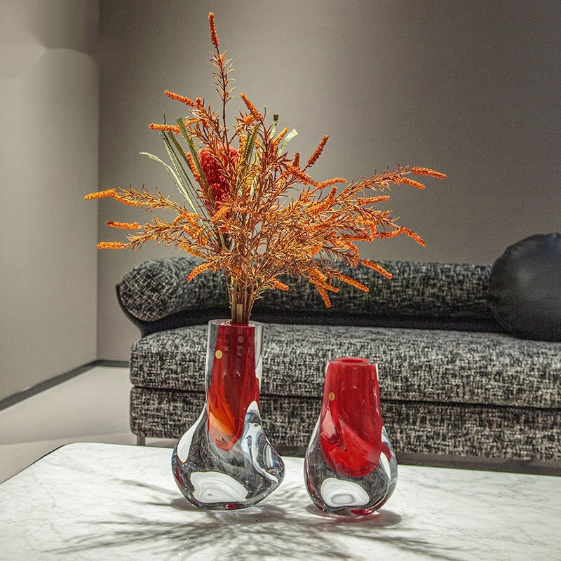 Two sculptural glass vases with red cores displayed in a modern living room