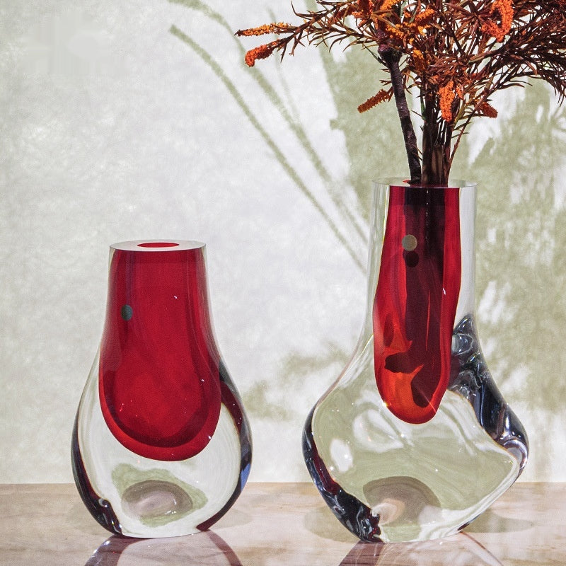 Sunlight passing through red and clear art glass vases creating shadows