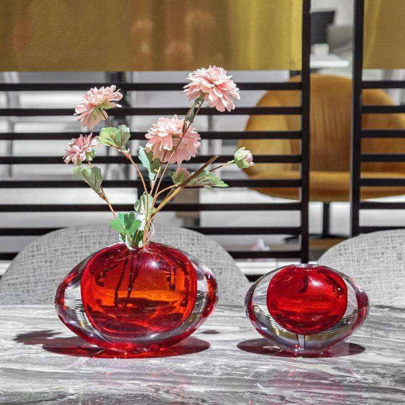 Set of two red and clear glass oval vases on marble table