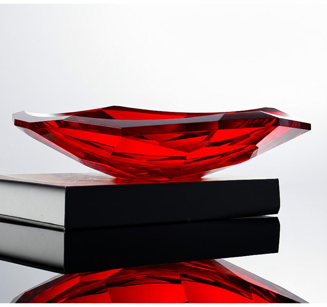 Profile view of ruby red crystal dish on books