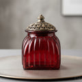 Red glass fluted decorative jar with dark metallic lid