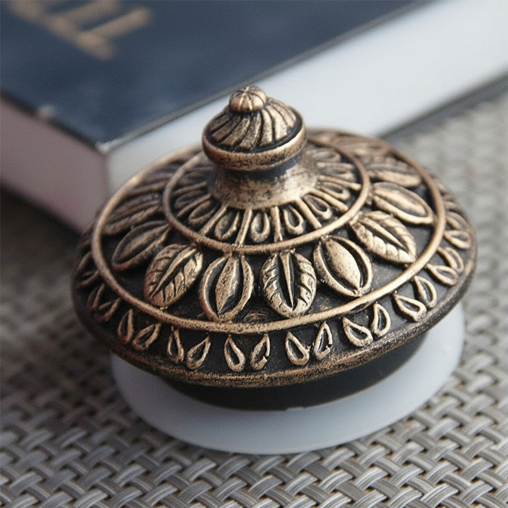 Close up of dark metallic lid with leaf motif