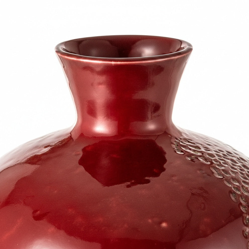 Close up of red glazed ceramic pomegranate vase texture