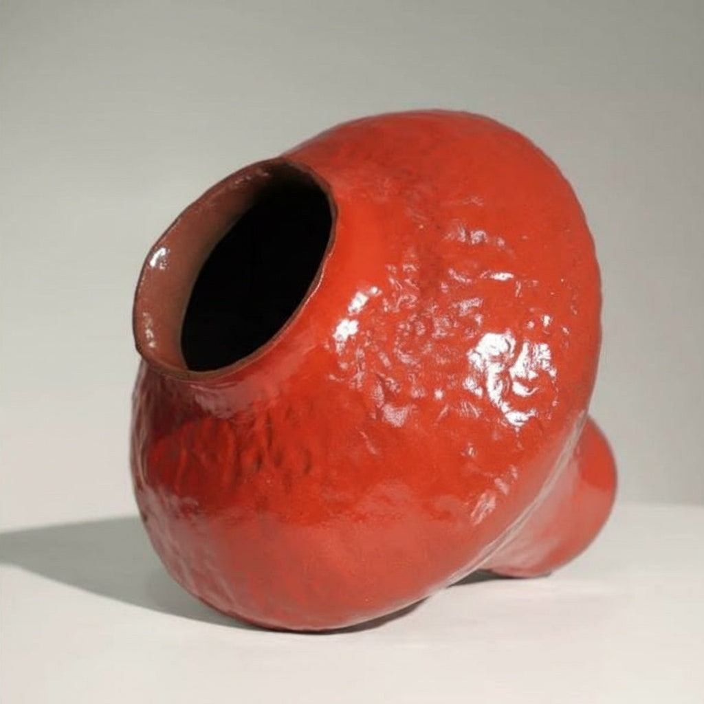 Top angle detail showing rim and textured glaze of red ceramic vase