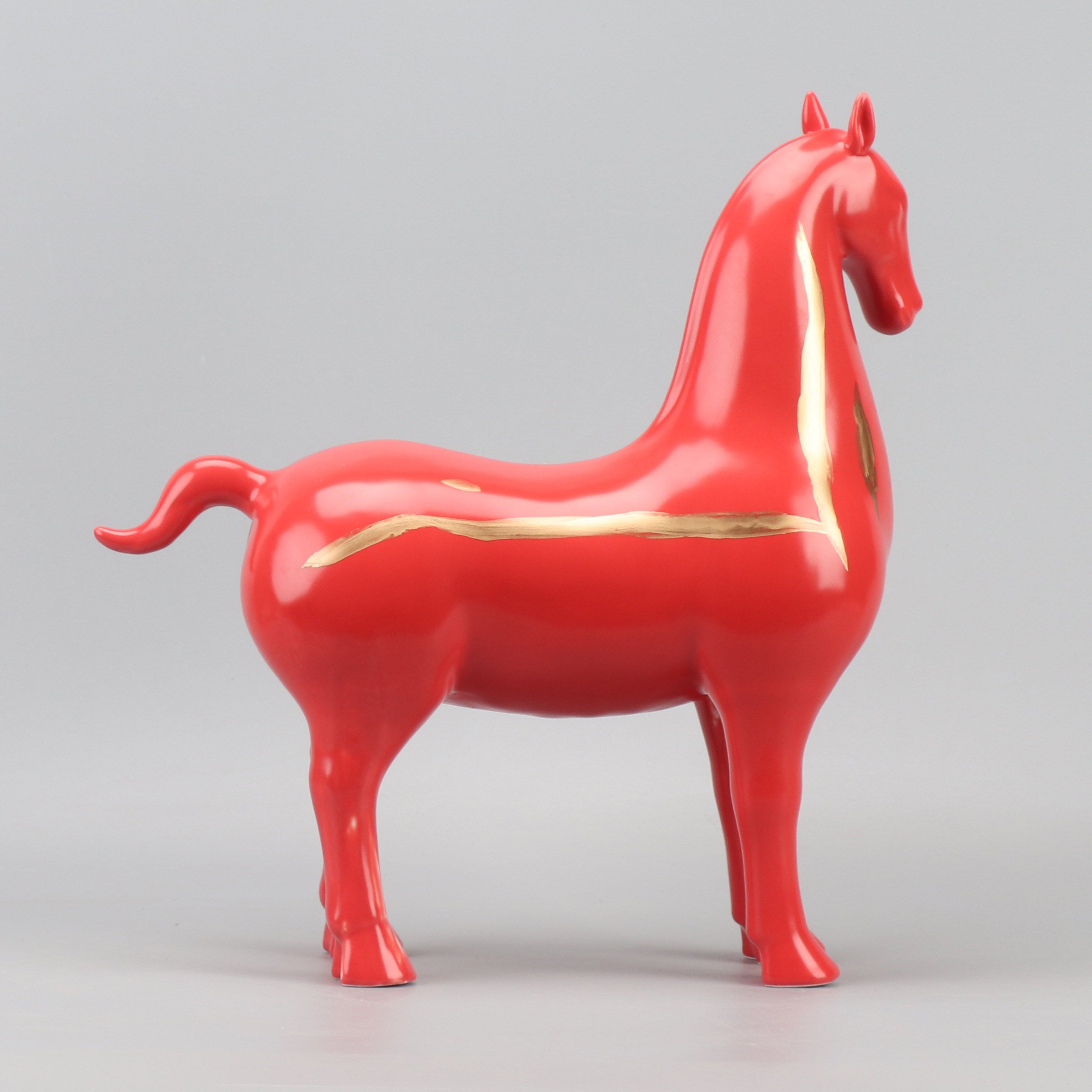 Angled view of red and gold minimalist horse statue