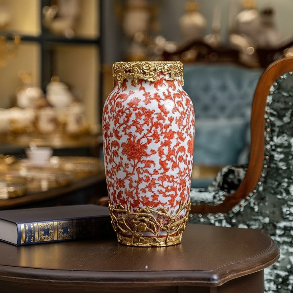 Red floral ceramic vase with gold finish metal accents on table
