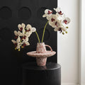 Red speckled ceramic geometric handled vase with orchids