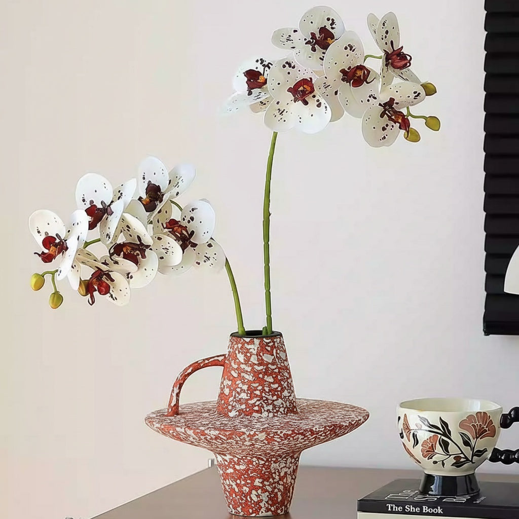 Red speckled ceramic geometric handled vase styled on a desk